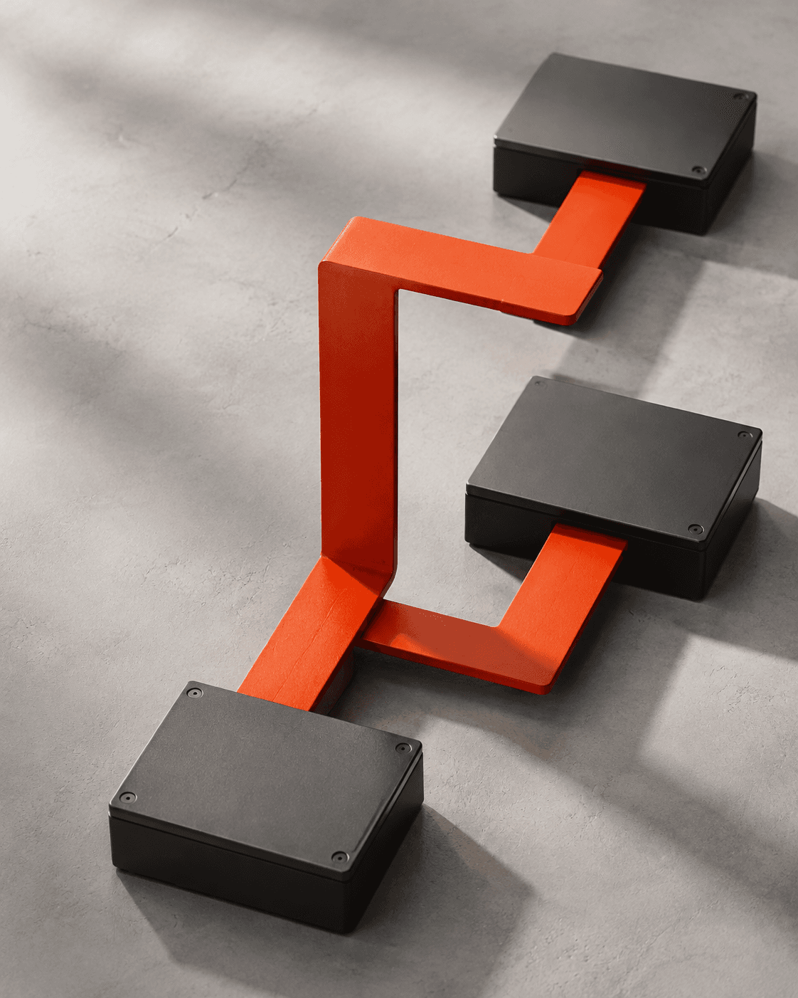 An orange architectural connection joining three graphite modules, a conceptual illustration of systems working together.